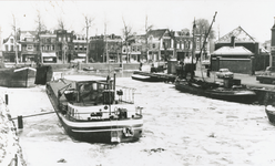 863457 Gezicht over de bevroren Stadsbuitengracht ter hoogte van de Nieuwe Kade (rechts) in Wijk C te Utrecht, vanaf de ...